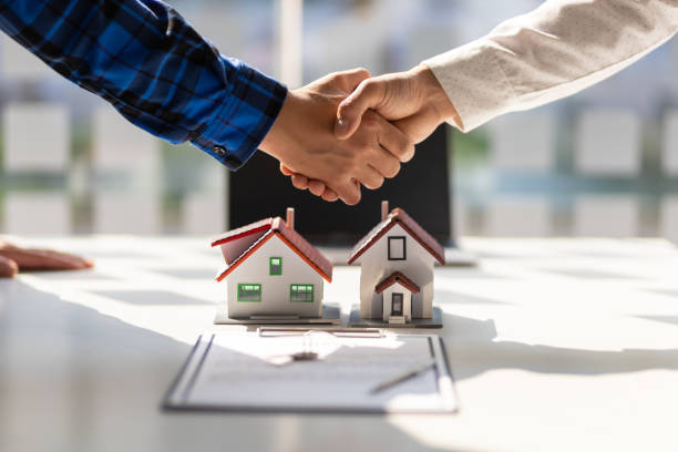 real_estate Real estate agents shake hands after the signing of the contract agreement is complete.
